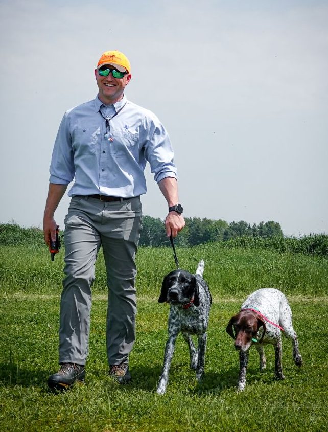 Mike in the field with his bird dogs